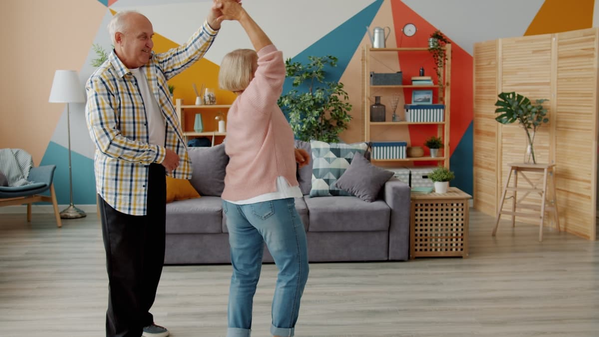 An older couple dancing in their living room