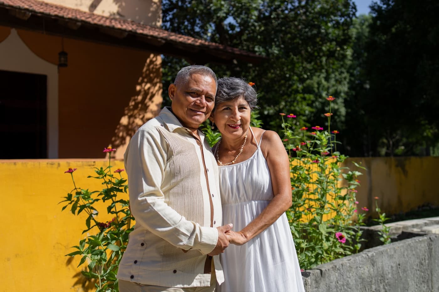 A couple in their sixties standing in front of their home
