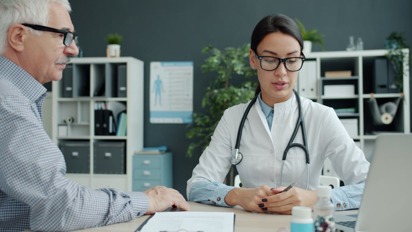 A doctor talking with an older patient in her office